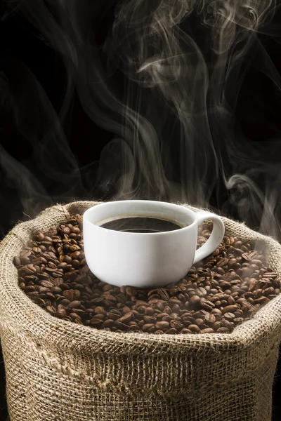 Sack full of still hot, freshly roasted coffee beans with the falling coffee beans. — Stock Photo, Image