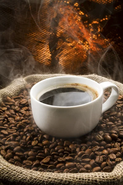 Sack full of still hot, freshly roasted coffee beans with the falling coffee beans. — Stock Photo, Image