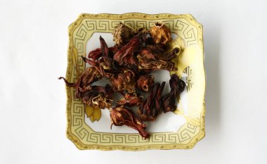 Kırmızı rosella çayı ya da tabakta amberçiçeği çayı. Beyaz arkaplan.