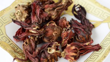 Kırmızı rosella çayı ya da tabakta amberçiçeği çayı. Beyaz arkaplan.