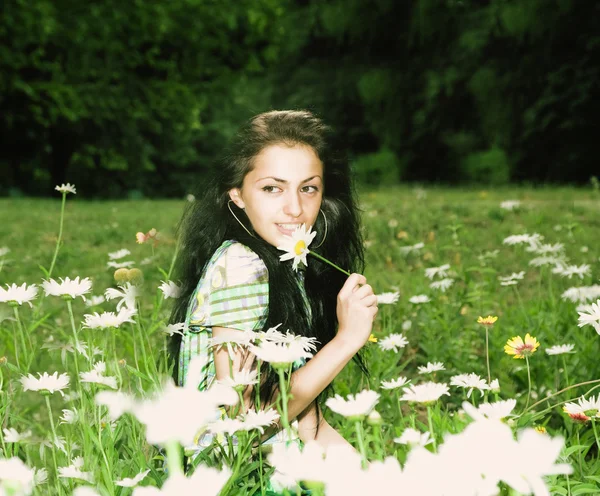 Hermosa chica en un campo de flores — Foto de Stock