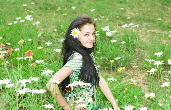 Hermosa chica en un campo de flores — Foto de Stock