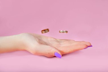 Uçuşta pembe bir arka planda. Yeni evlilerin düğünü. Çift bir aile yaratıyor. Sonsuza dek birlikte. Evlilik bağı evliliği. kız avucu