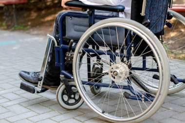 Sokakta tekerlekli sandalyedeki engelli biri. Engelli taşıma. Genç bir adam araba kazası geçirdi. Omurilik kırığı. Sağlık sorunları. sınırlı özellikler