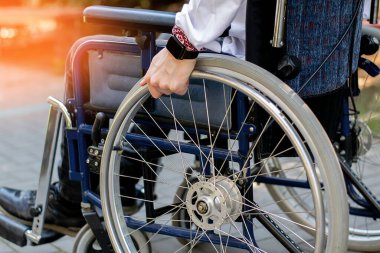 Sokakta tekerlekli sandalyedeki engelli biri. Engelli taşıma. Genç bir adam araba kazası geçirdi. Omurilik kırığı. Sağlık sorunları. sınırlı özellikler