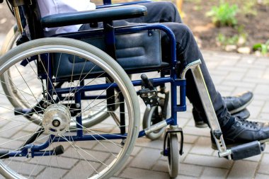 Adam tekerlekli sandalyede sakat. Doğa detayları bebek arabası. Sırt sakatlığı sınırlı. Araba kazası. Yaralandıktan sonra rehabilitasyon