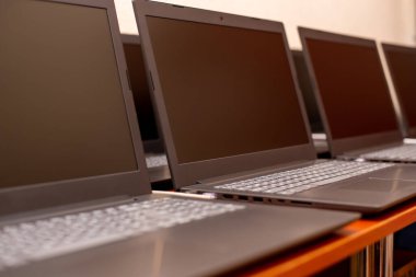 Masada bir sürü dizüstü bilgisayar var. Teknoloji sergisi. Ofiste birkaç bilgisayar var. Bu bir iş. Gri defter anahtarları. teçhizat çalışanları