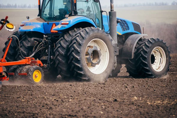 tractor on the field farming in the village and village sowing in the spring agronomist on a combin