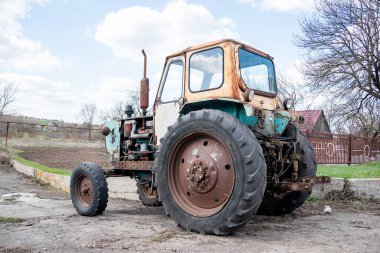 Eski bozuk traktör. Köydeki terk edilmiş, paslı kırsal ekipman hareket halinde değil.