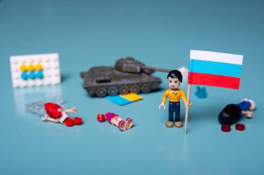 Ukrayna bayrağı dumanlı lego adam ve mavi arka planda bir tank. Vatansever ülke savaşı kavramı Rusya ve Ukrayna