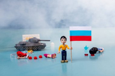 Ukrayna bayrağı dumanlı lego adam ve mavi arka planda bir tank. Vatansever ülke savaşı kavramı Rusya ve Ukrayna