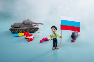 Ukrayna bayrağı dumanlı lego adam ve mavi arka planda bir tank. Vatansever ülke savaşı kavramı Rusya ve Ukrayna