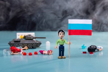 Ukrayna bayrağı dumanlı lego adam ve mavi arka planda bir tank. Vatansever ülke savaşı kavramı Rusya ve Ukrayna