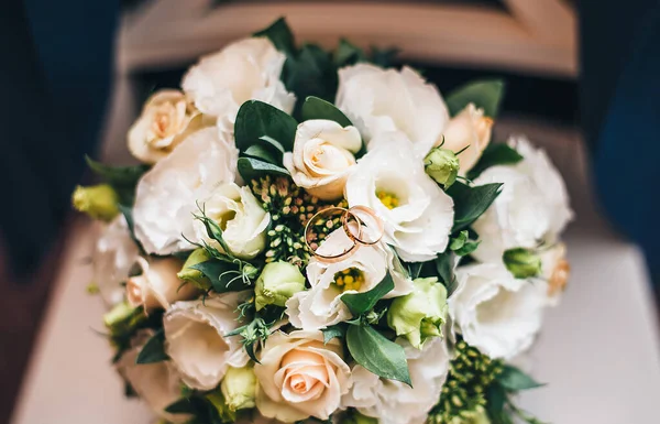 wedding rings on a bouquet of light rose flowers. wedding decoration