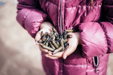 Ukrayna 'da, Mariupol şehrinde savaş. Bir çocuğun elindeki mermi kovanları. Rus askeri saldırısı Ukrayna 'da