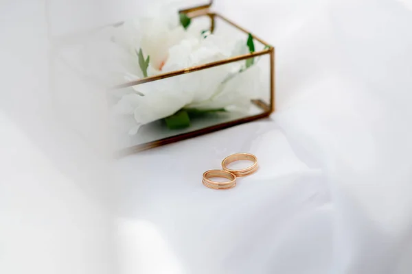 婚礼金戒指在玻璃盒的背景上 白色面料的背景 新娘和新郎仪式的活动机构概念 — 图库照片