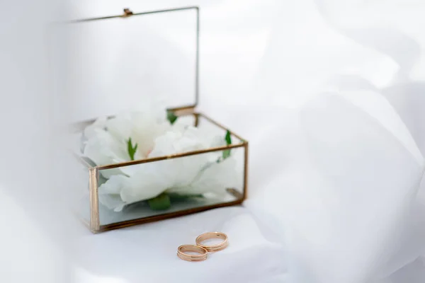 婚礼金戒指在玻璃盒的背景上 白色面料的背景 新娘和新郎仪式的活动机构概念 — 图库照片