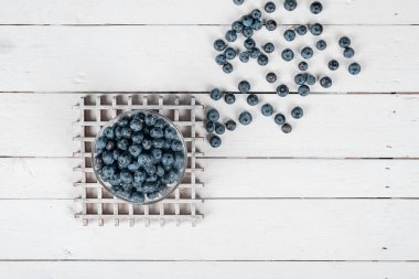 Beyaz ahşap bir masada yaban mersini. Kırsal ve sağlıklı kahvaltı. düz la