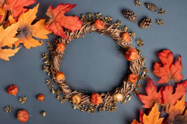 Gri arkaplanda sonbahar dekoratif çelenkleri ve kırmızı turuncu yapraklar. Metin yazma konsepti. kopyalama alanı, düz la