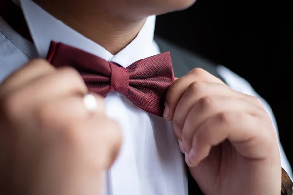 the groom straightens the bow tie before the wedding. close-up. idea for event agencie