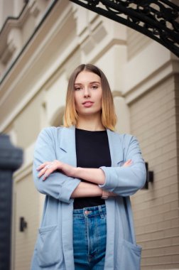 Mimari bir binanın arka planında başarılı mutlu bir kızın portresi. İş stili. Kendine güvenen iş kadını. 