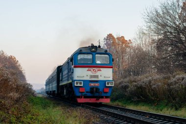 CHERNIVTSI, UKRAINE - 29 Ekim 2021. DPL1-004 treni ve 2M62-1114 lokomotifi Chernivtsi sokaklarında yolcularla yolculuk ediyor..