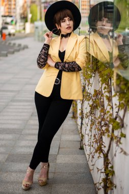 Sarı ceketli ve siyah şapkalı bir kızın dikey portresi..