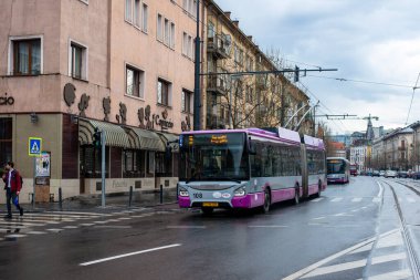CLUJ-NAPOKA, ROMANIA - 27 Nisan 2022. Trolleybus Astra ICPE-SAERP Kasaba 118 # 108 ve Solaris Urbino Otobüs 18 # 818 Cluj-Napoka sokaklarında yolcularla birlikte.