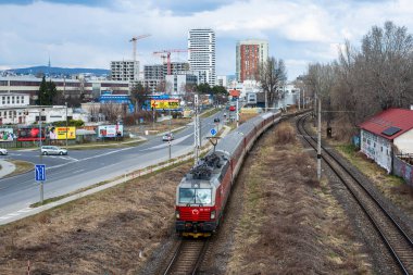 BRATISLAVA, SLOVAKIA - 28 Şubat 2022. Lokomotif Siemens Vectron MS # 383 105-4 Bratislava sokaklarında yolcularla at sürüyor.