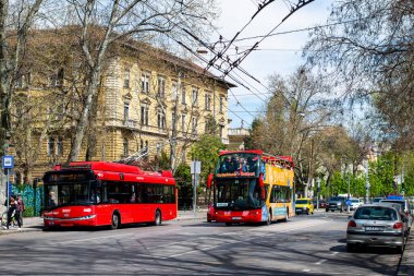 BUDAPEST, HUNGARY - April 14, 2022. Trolleybus Solaris Trollino 12 Skoda #8007 and bus Ayats Bravo (Volvo) riding with passengers in the streets of Budapest.