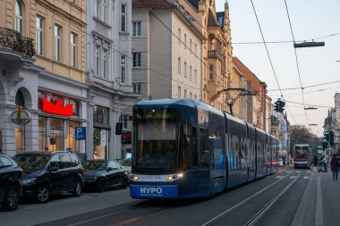 LINZ, AUSTRIA - MARCH 26, 2022. Tram Bombardier Flexity Outook #060 riding with passengers in the streets of  Linz.