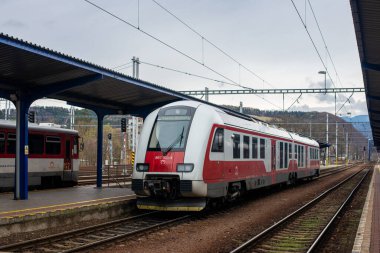 BANSKA BYSTRICA, SLOVAKIA - Nisan 09, 2022. 861-103-4 numaralı tren Banska Bystrica sokaklarında yolcularla birlikte ilerliyor..