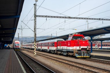 BRATISLAVA, SLOVAKIA 15 Mart 2022. Train Skoda Vagonka 1ev # 971 018-7 ve lokomotif ZOS Svolen 62A # 736 101-7 Bratislava sokaklarında yolcularla birlikte.