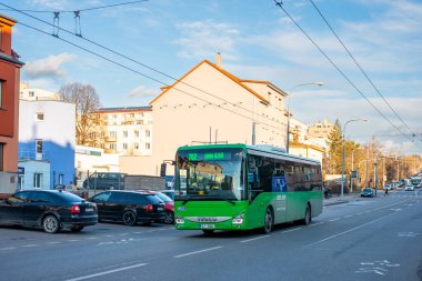 BRNO, ÇEK CUMHURİYETİ - 25 Şubat 2022. Iveco kavşağı 12M otobüsü Brno sokaklarında yolcularla yolculuk ediyor..