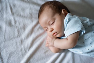 Yeni doğan bebek tatlı rüyalarla huzur içinde uyur. Sevimli yeni doğmuş çocuk tatlı tatlı uyuyor.