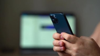 iPhone 12 'yi kullanan bir adam parmak basıyor, sosyal medya interneti okuyor, mesaj yazıyor ya da internetten alışveriş yapıyor. Cep telefonu iki elle evde ya da 14.01.22 Moskova Rusya 'da çalışıyor..