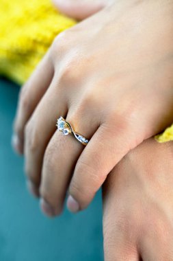 Güzel bir nişan yüzüğü takan genç bir kadın.