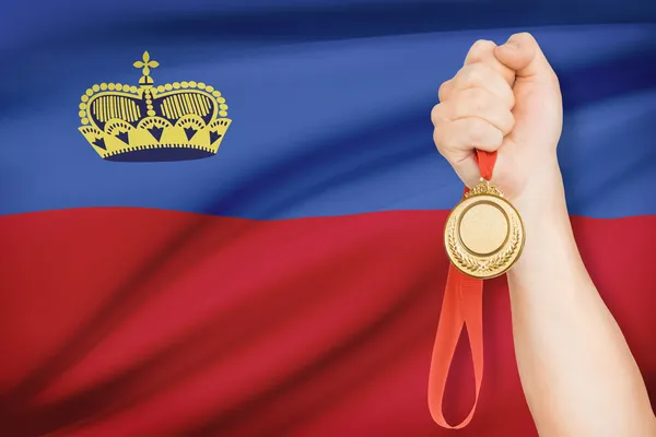 Medal in hand with flag on background - Principality of Liechtenstein — Stock Photo, Image