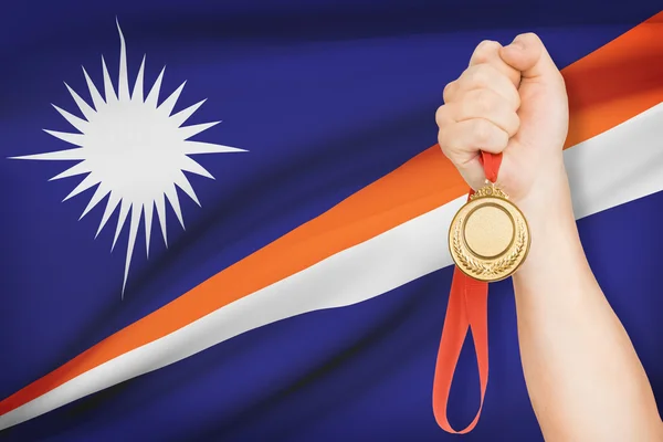 Medal in hand with flag on background - Marshall Islands — Stock Photo, Image