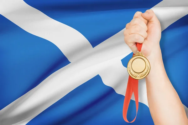 Medal in hand with flag on background - Scotland — Stock Photo, Image
