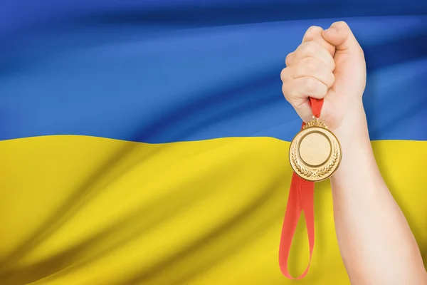Medal in hand with flag on background - Ukraine – stockfoto