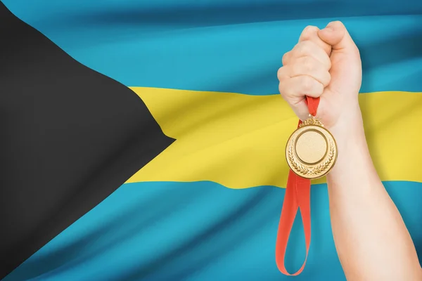 Medaille in der hand mit Flagge auf Hintergrund - bahamas — Stockfoto