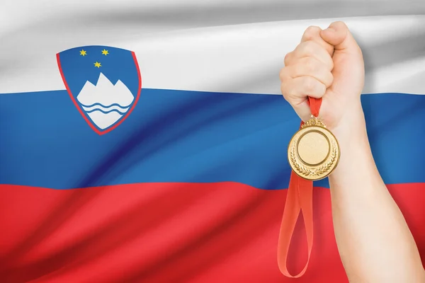 Medaille in de hand met vlag op achtergrond - Republiek Slovenië — Stockfoto