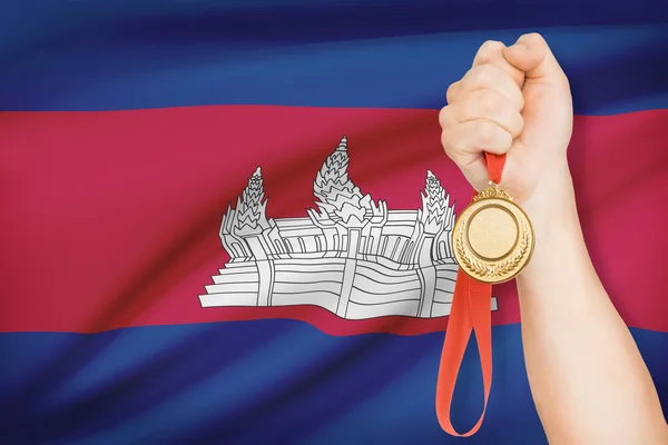 Medaille in der hand mit Flagge auf Hintergrund - Königreich von Kambodscha — Stockfoto