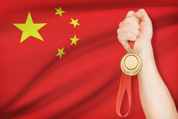 Medalha na mão com bandeira no fundo - República Popular da china — Fotografia de Stock