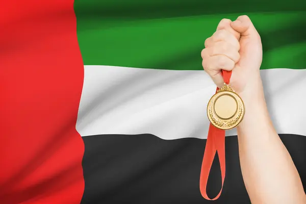 Medaille in der hand mit Flagge auf Hintergrund - Vereinigte Arabische Emirate — Stockfoto