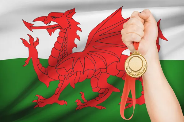 Медаль в руку с флагом на фоне - Уэльс — стоковое фото