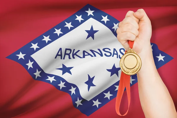 Medaille in der hand mit Flagge auf Hintergrund - Bundesstaat Arkansas. Teil einer Serie. — Stockfoto