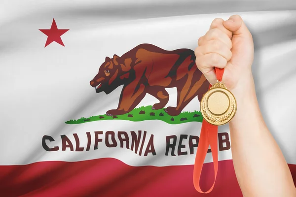 Medal in hand with flag on background - State of California. Part of a series. — Stock Photo, Image