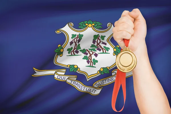 Medaille in de hand met vlag op achtergrond - staat connecticut. bij een reeks hoort. — Stockfoto